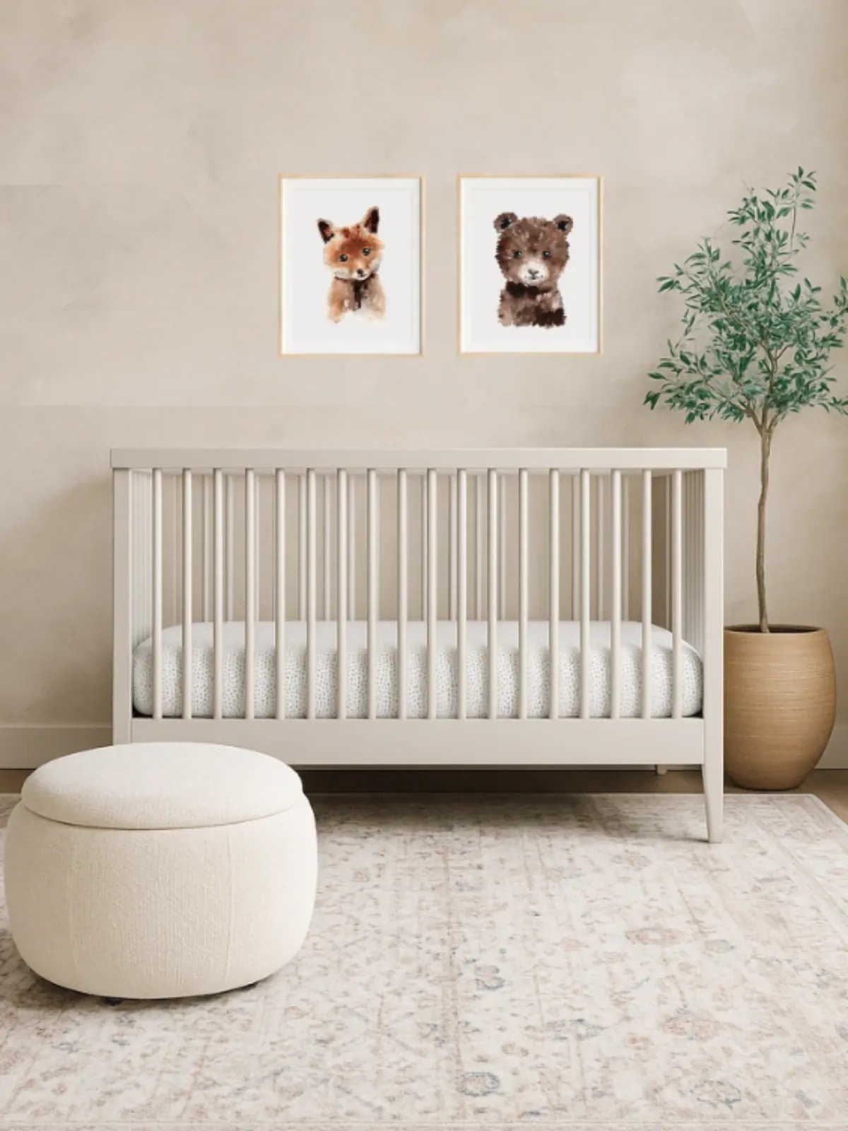 A warm neutral nursery with a cream crib and fox and bear prints